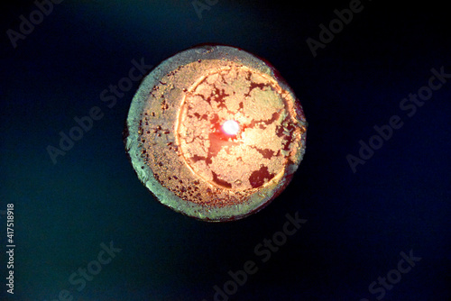 the view from the top at the top of the birning candle with golden layer ob the red wax