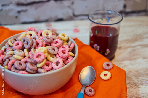 bad breakfast of colorful cereals full of sugar with red fruit juice