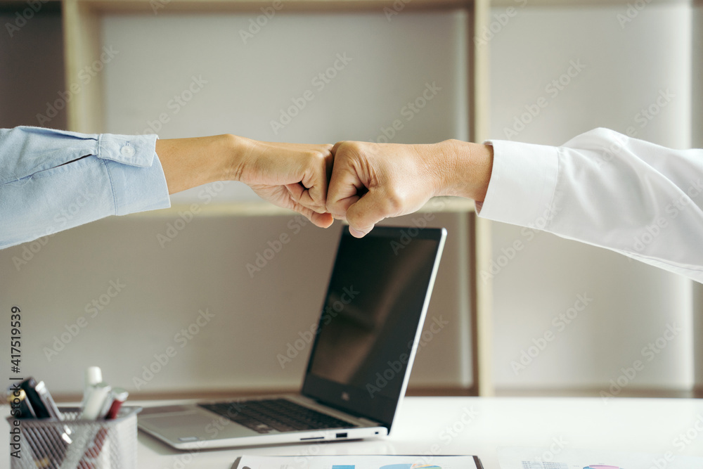 Two businesspeople fist bump dealing mission business with smile