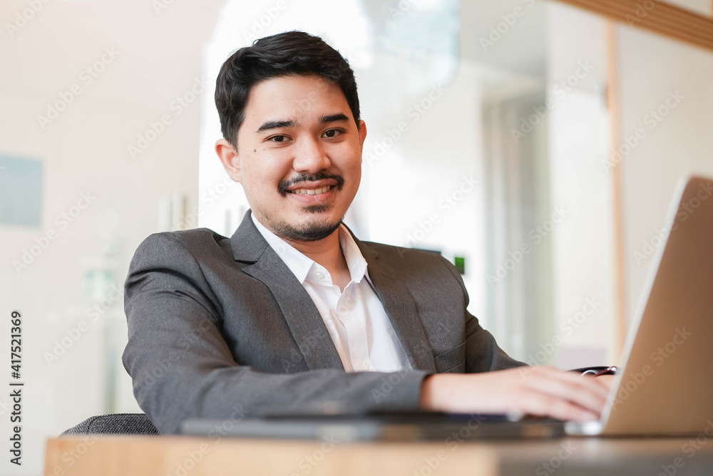 close up middle eastern adult businessman sitting at table while working on laptop in office room for business service lifestyle concept close up middle eastern adult businessman sitting at table while working on laptop in office room for business service lifestyle concept