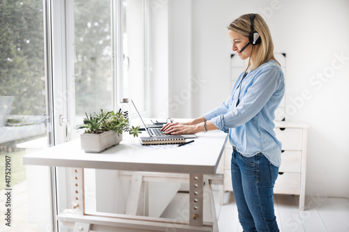 Businesswoman working at ergonomic standing workstation