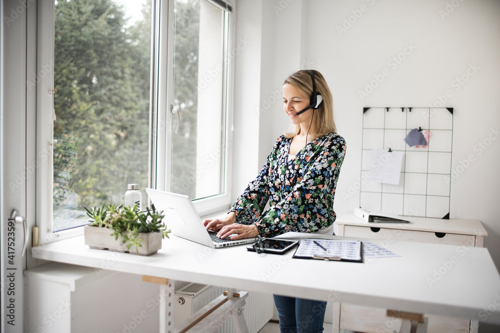 Businesswoman working at ergonomic standing workstation