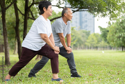 Asian Senior man and woman doing exercise at park outdoor in the morning.