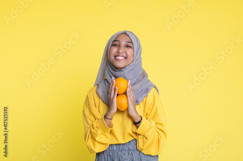 woman with orange on yellow background. © faishalabdula