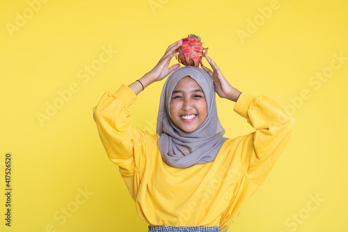 beautiful girl with dragon fruit on yellow background © faishalabdula