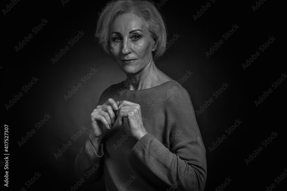 Classic black-and-white dramatic portrait of elderly blonde woman in Studio on black background Classic black-and-white dramatic portrait of elderly blonde woman in Studio on black background
