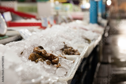 Sweet clams are placed on ice trays in the fresh market.