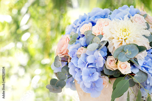 Large bouquet of roses, dahlias, hydrangeas, eucalyptus leaves in a clay pot