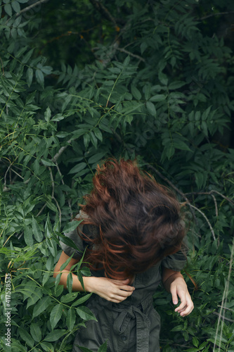 Portrait of a woman Leaned forward and the green leaves of the Bushes nature travel  #417528535