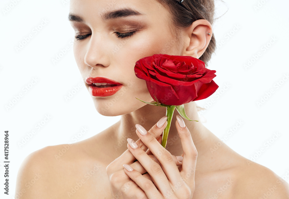 Woman with closed eyes Makeup on face and red flower naked shoulders Woman with closed eyes Makeup on face and red flower naked shoulders