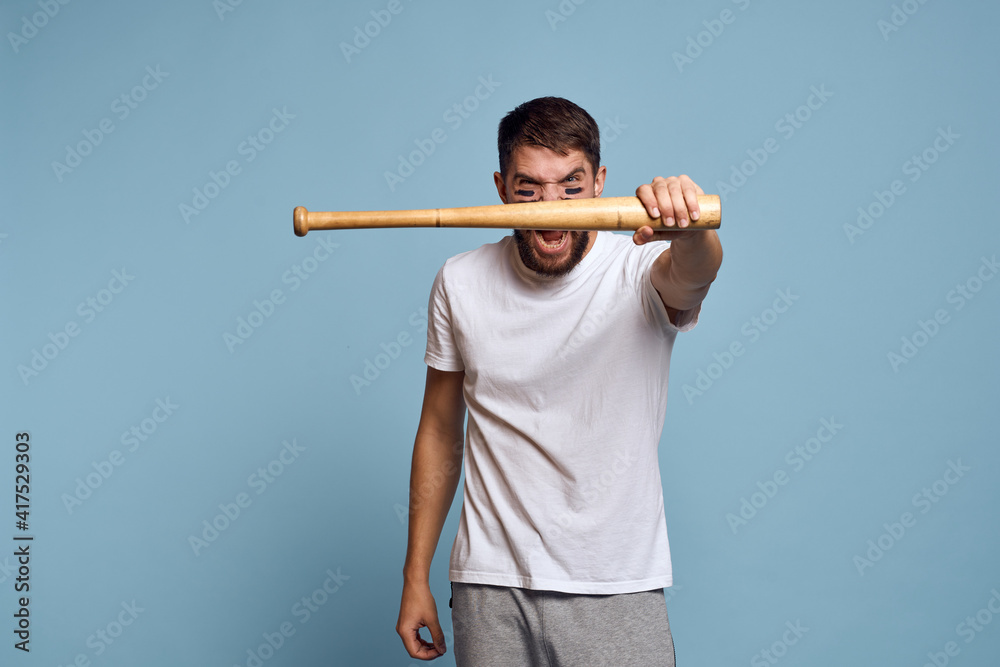 Man in white t-shirt baseball bat sport blue background Man in white t-shirt baseball bat sport blue background