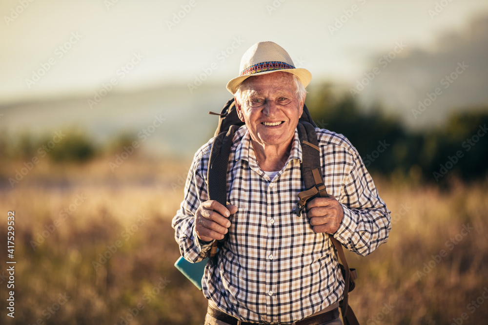 Happy old man just reaches the top of hill.Handsome senior man hiking, exploring. Happy old man just reaches the top of hill.Handsome senior man hiking, exploring.