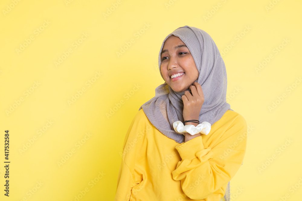 Fashion portrait of young beautiful asian muslim woman with wearing hijab isolated on yellow background. Fashion portrait of young beautiful asian muslim woman with wearing hijab isolated on yellow background.