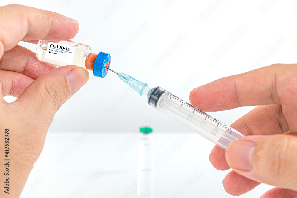 A man's hand holds a vaccine against COVID-19. A man's hand holds a vaccine against COVID-19.