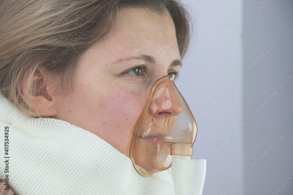 portrait of a young woman inhaling medicines for bronchitis and asthma at home portrait of a young woman inhaling medicines for bronchitis and asthma at home