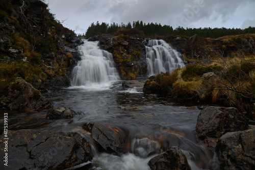 double waterfall in river with silky water. dry autumn grass- Fairy Pools - Skye Island - Scotland - Uk