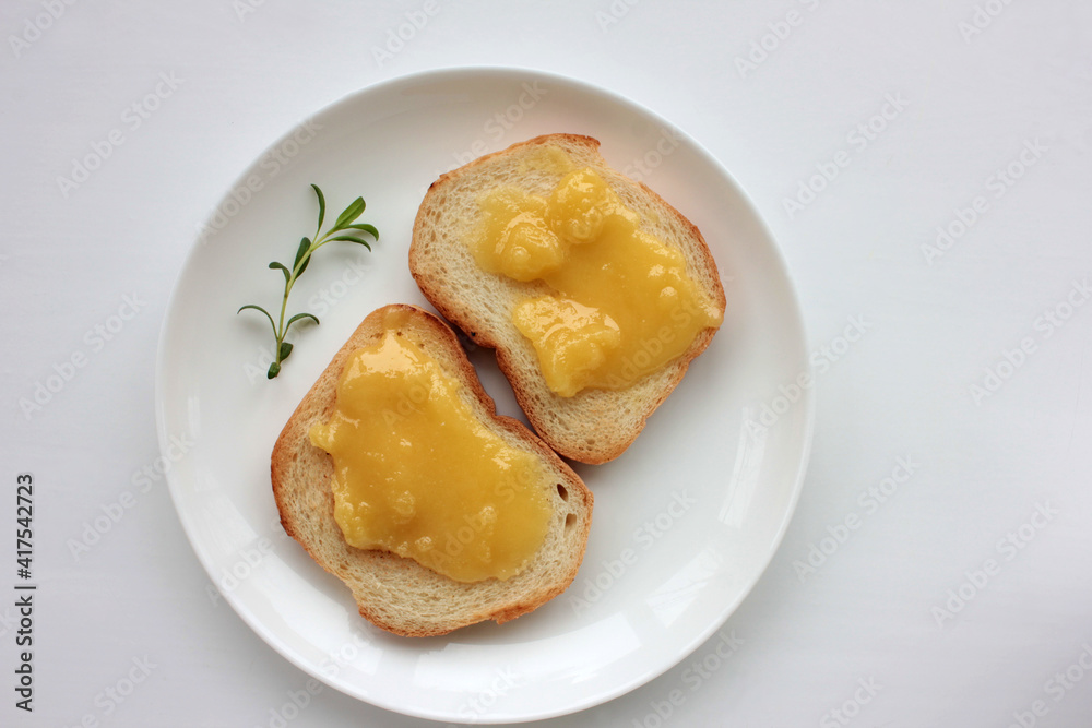 Toast bread with organic honey on plate on white table background. Healthy breakfast concept. Top view, copy space.
