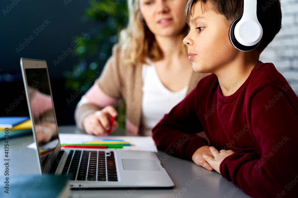 Close up of mother assists her son while studying remotely Close up of mother assists her son while studying remotely