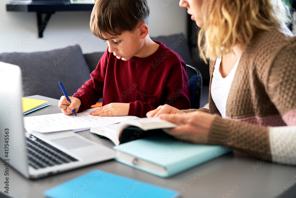 Boy doing homework with his mother during the lockdown Boy doing homework with his mother during the lockdown