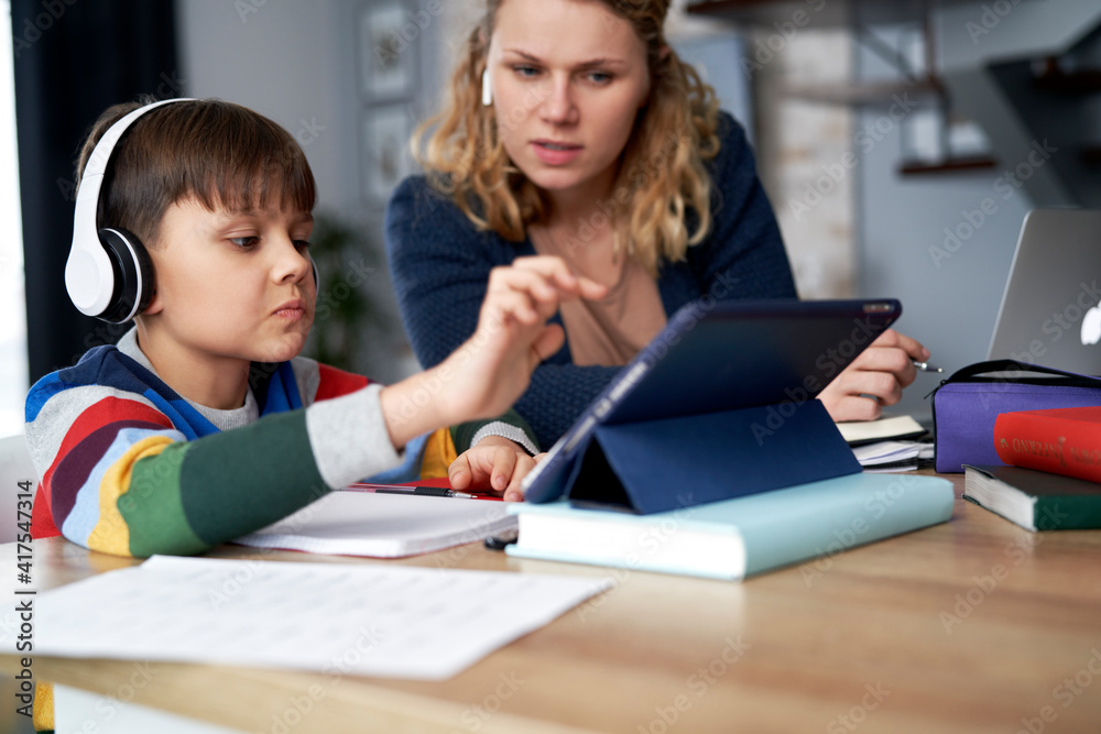 Mother assists her son while studying remotely Mother assists her son while studying remotely