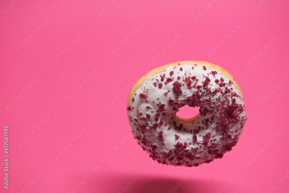 Macro shoot of hanging white donut over pink background Macro shoot of hanging white donut over pink background