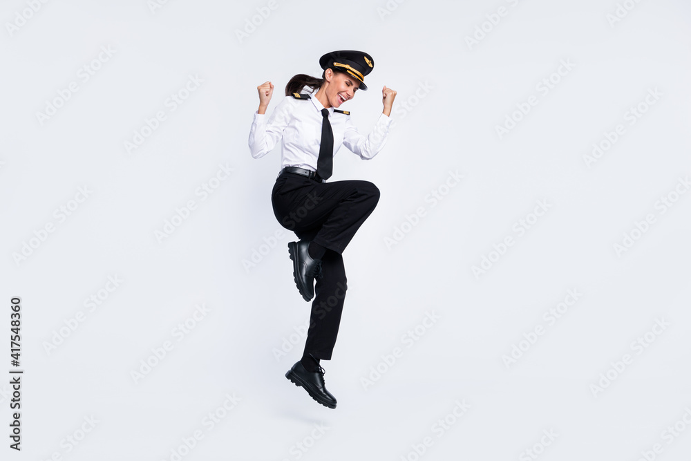 Full length body size view of attractive lucky cheerful pilot girl jumping rejoicing having fun isolated over white color background Full length body size view of attractive lucky cheerful pilot girl jumping rejoicing having fun isolated over white color background
