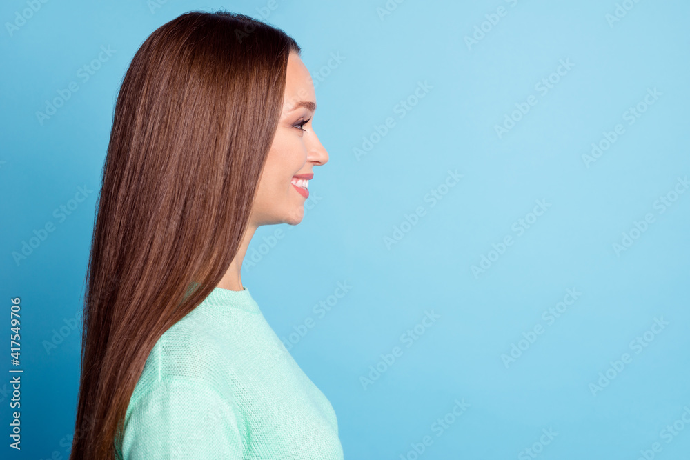 Profile photo portrait of smiling girl looking at blank space isolated on pastel blue colored background