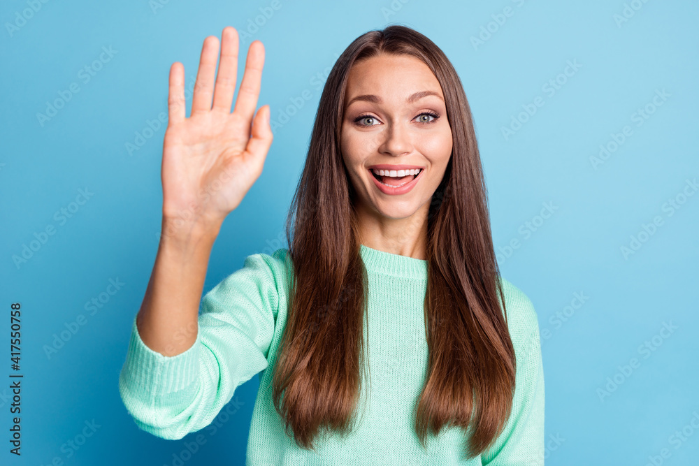 Portrait of attractive cheerful brown-haired girl waving hi hello greetings meet date isolated over bright blue color background Portrait of attractive cheerful brown-haired girl waving hi hello greetings meet date isolated over bright blue color background