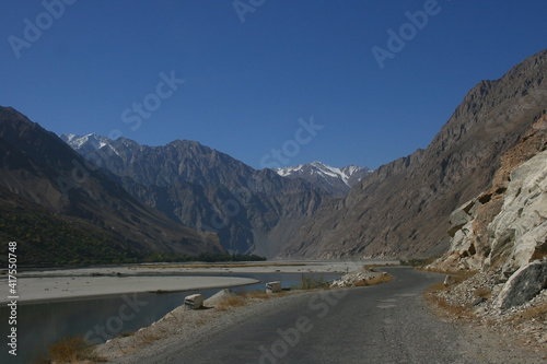 River Panj (Pyandzh) between Tajikistan and Afghanistan. Pamir Highway road carved in the left. Pamir Mountains, Central Asia. Swift Blue River. 