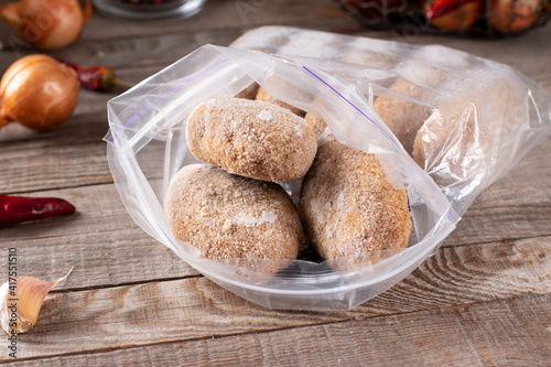 Plastic bags with frozen meat and cutlets in plastic bag on a table photo