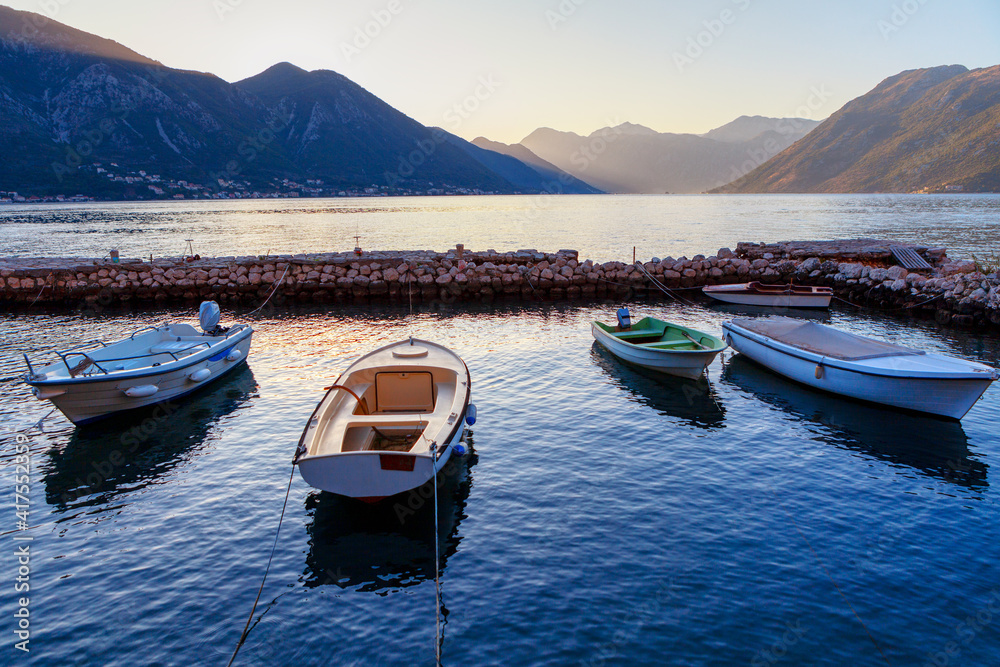 Boats anchored in the lagoon with mountains . Fishing boats on the harbor in the twilight