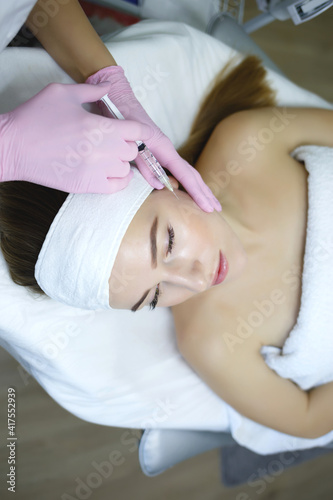 Cosmetologist does injections anti wrinkle of a beautiful woman. Women's cosmetology in the beauty salon.