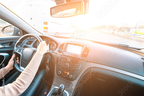 Travel trip car. Happy young woman inside vehicle driving in sunny day. Fun driver ride in winter vacation concept. © Maksym