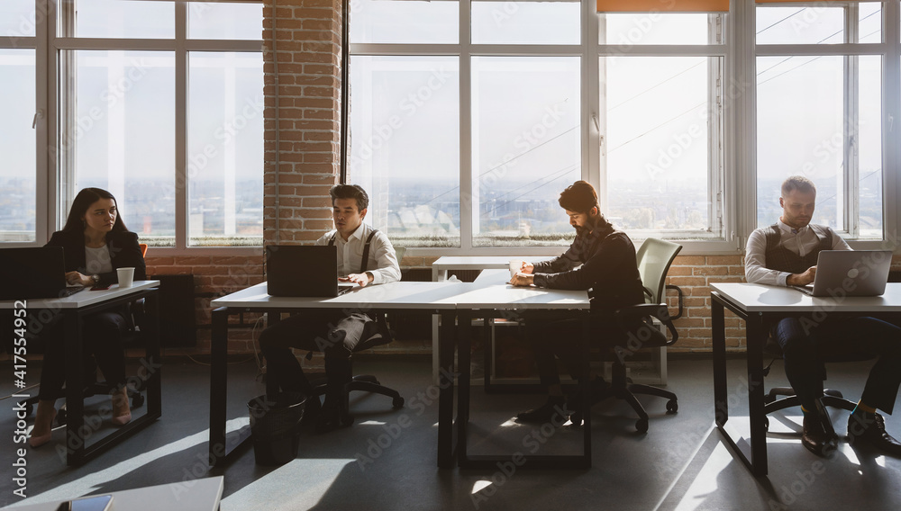 Group of young business people in smart casual wear working together in office. Team at work. Group of young business people in smart casual wear working together in office. Team at work.