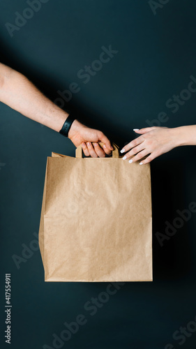 Disposable bag of kraft paper. Food delivery, hand-to-hand package transfer.