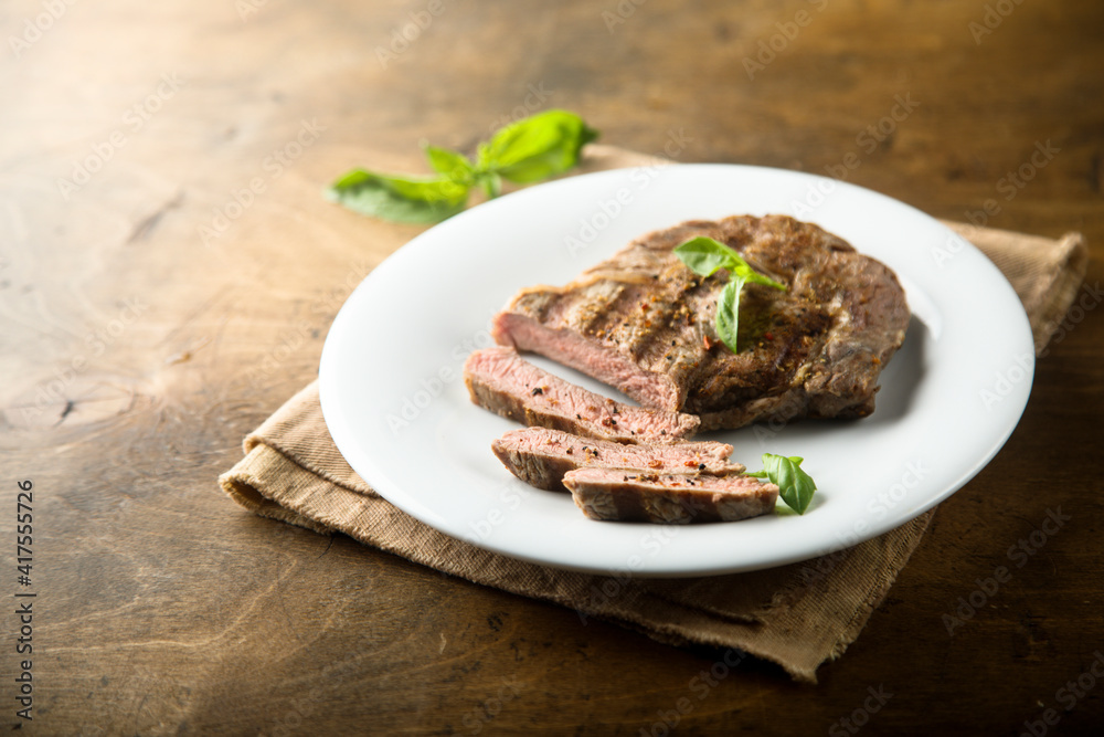 Delicious grilled beef steak with fresh basil