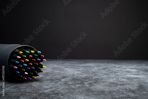 Back to school: colored pencil set on concrete background texture
