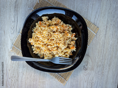Obraz na płótnie photo of pilaf in a black plate on a white background. rice dish. photo of food. View from above. w salonie