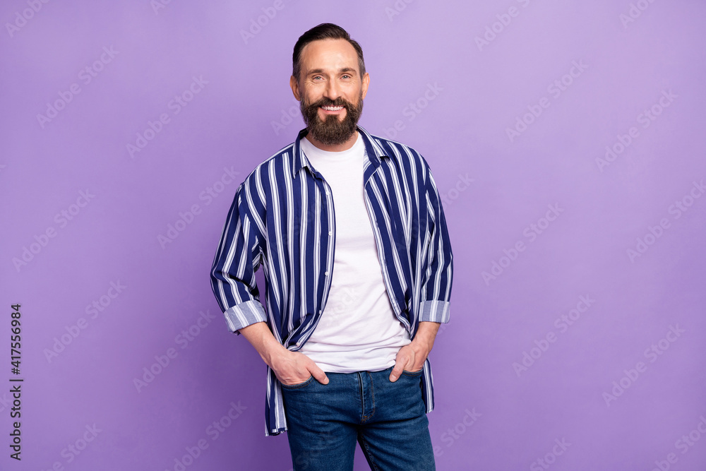 Obraz premium Photo of positive cool bearded guy hands pockets look camera wear striped shirt isolated violet color background
