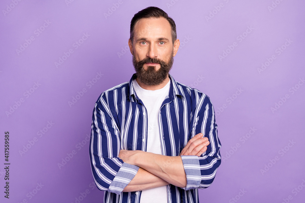 Photo of serious focused mature man crossed hands isolated over violet color background Photo of serious focused mature man crossed hands isolated over violet color background