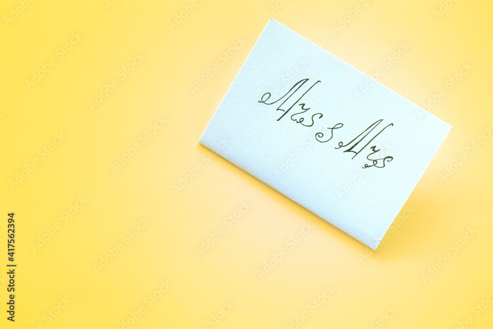 White paper card with the inscription Mrs and Mrs on yellow background. Lesbian wedding White paper card with the inscription Mrs and Mrs on yellow background. Lesbian wedding