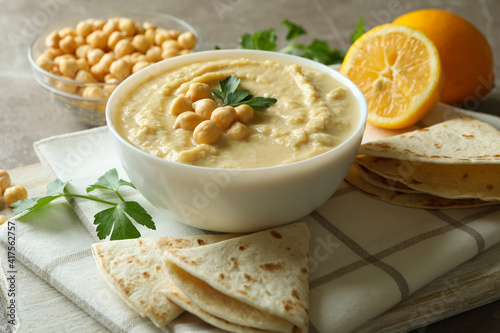 Concept of tasty eat with bowl of hummus on gray background