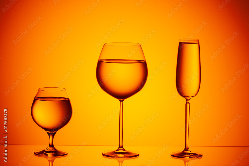Set of four wine glasses on yellow background