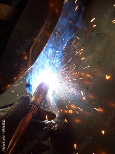 worker welding equipment parts in the workshop