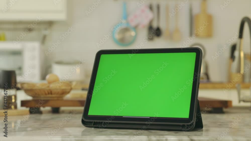 Tablet with green screen chroma key . In kitchen at home. Tablet with green screen chroma key . In kitchen at home.