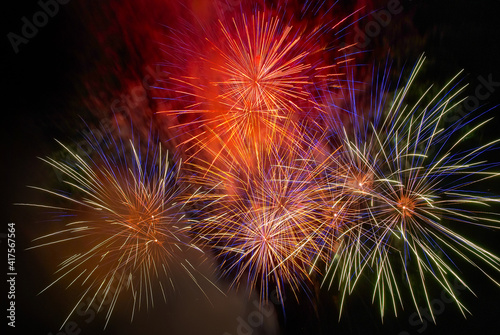 Red colorful fireworks on the black sky background. Holiday celebration