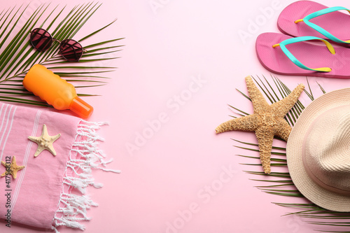 Beach accessories on pink background, flat lay. Space for text