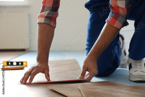 Professional worker installing new parquet flooring indoors  closeup