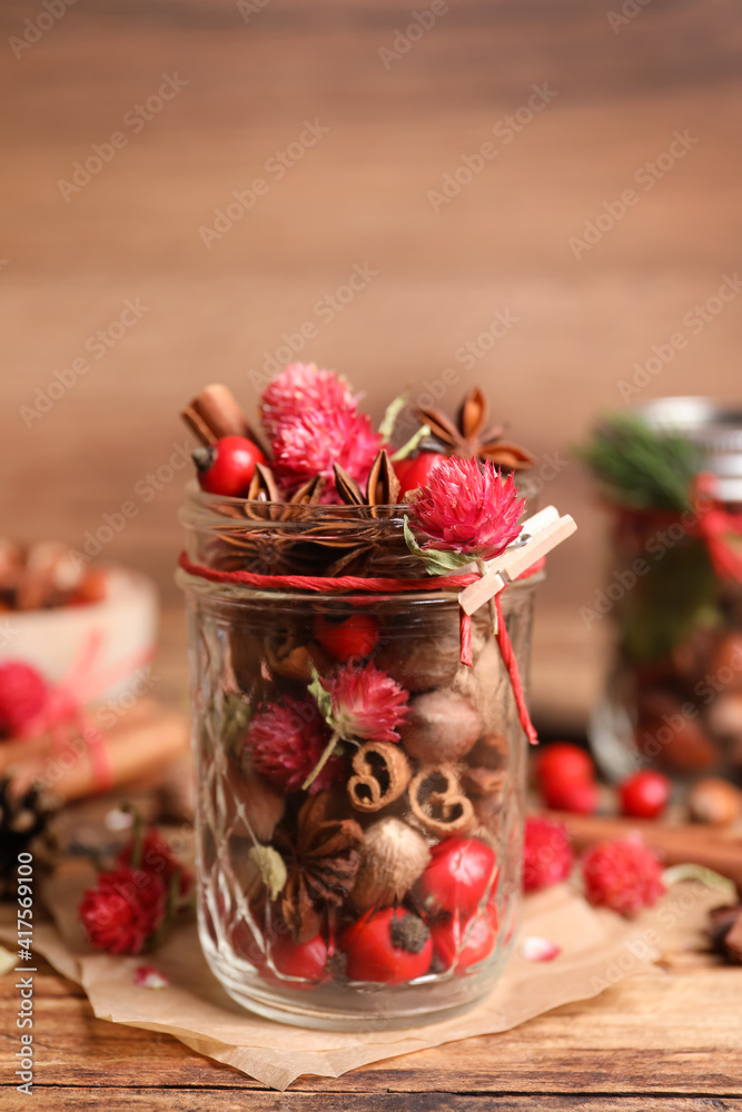 Aromatic potpourri in glass jar on wooden table