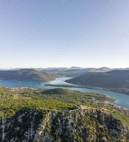 Aerial drone shot of City Wall of Ston over hill to Mali Ston in Croatia summer morning sunrise